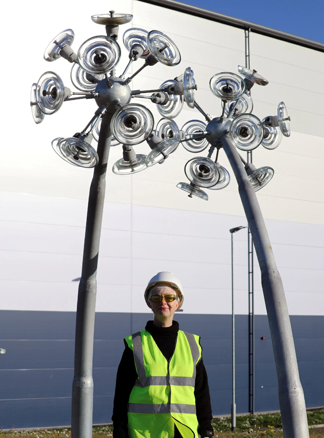Artist Ailsa Magnus with her dandelion sculpture using reclaimed glass insulators from the transmission network